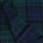 Close up view of soft navy and green cotton flannel plaid fabric with red overcheck